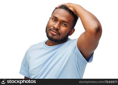 grooming, hairstyling and people concept - young african american man touching his hair over white background. african american man touching his hair