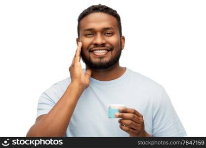 grooming, skin care and people concept - happy african american man applying wax to his beard over white background. happy african man applying wax to his beard