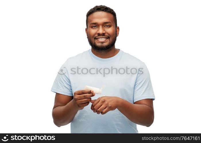 grooming, skin care and people concept - happy african american man applying moisturizer to his hand over white background. happy african man applying moisturizer to his hand