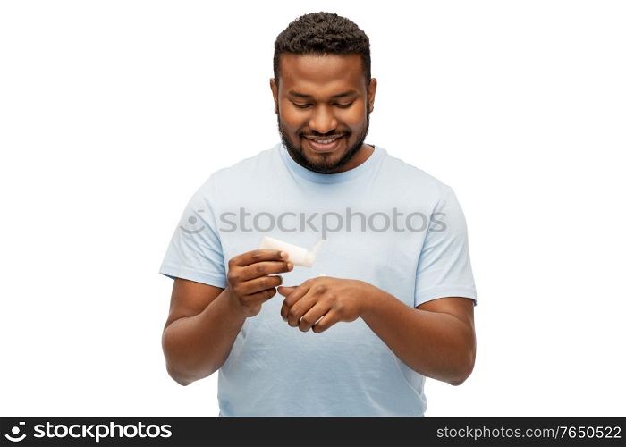 grooming, skin care and people concept - happy african american man applying moisturizer to his hand over white background. happy african man applying moisturizer to his hand
