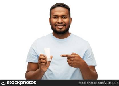 grooming, skin care and people concept - happy smiling african american showing moisturizer over white background. happy african american man showing moisturizer