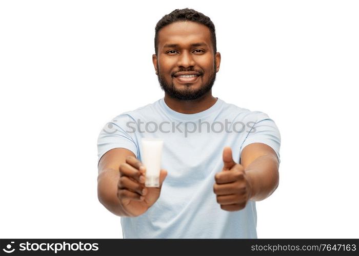 grooming, skin care and people concept - happy smiling african american with moisturizer showing thumbs up over white background. african man with moisturizer showing thumbs up