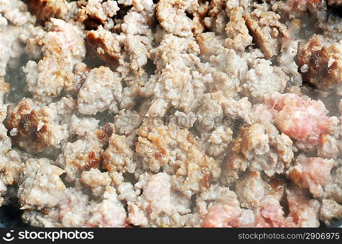 ground beef frying in pan close up