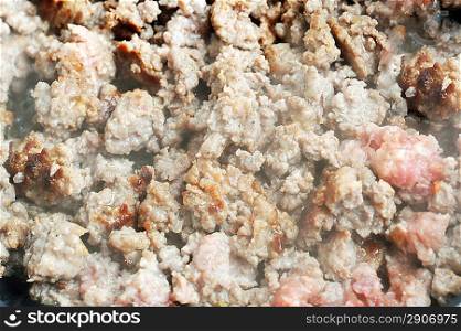ground beef frying in pan close up