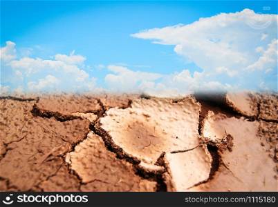 Ground broken drought land cracked soil and blue sky clouds