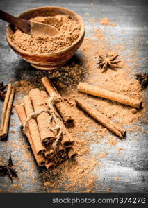 Ground cinnamon in a bowl. On a black wooden table.. Ground cinnamon in a bowl.