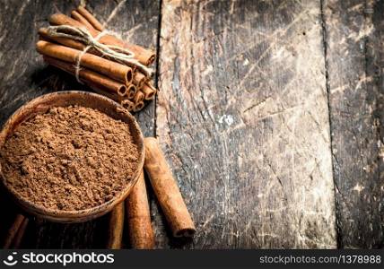 Ground cinnamon in a bowl. On wooden background.. Ground cinnamon in a bowl.