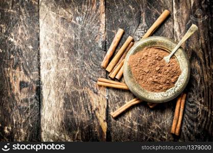Ground cinnamon in a bowl. On wooden background.. Ground cinnamon in a bowl.
