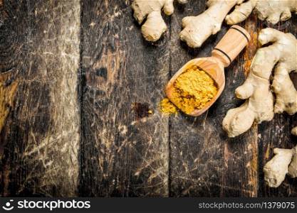 Ground ginger in a scoop. On wooden background.. Ground ginger in a scoop.
