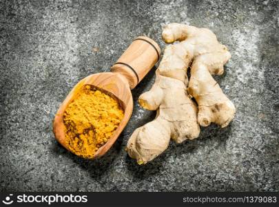 Ground ginger in a wooden scoop. On rustic background.. Ground ginger in a wooden scoop.