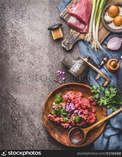 Ground meat stuffing preparation on kitchen table background with meat, force meat , meat grinder and spoon, top view. Cooking,recipes and eating concept