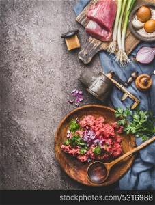 Ground meat stuffing preparation on kitchen table background with meat, force meat , meat grinder and spoon, top view. Cooking,recipes and eating concept