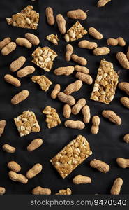 Groundnuts and chikki scattered on a black cloth.