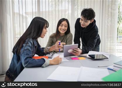 Group Asian Students Smile and reading book and using notebook for helps to share ideas in the work and project. And also review the book before the exam
