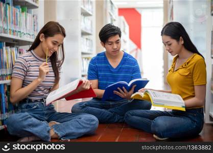 Group Asian Students Smile and reading book and using notebook for helps to share ideas in the work and project. And also review the book before the exam