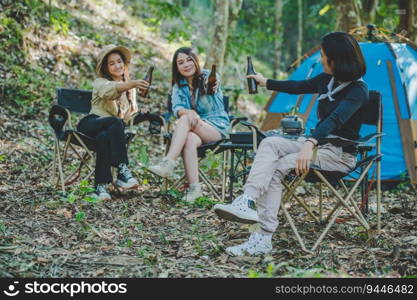 Group beautiful Asian women friends travelers relaxing in camp chairs at tent, They are cheering and drinking beer during camping, talking with fun and happy together, copy space