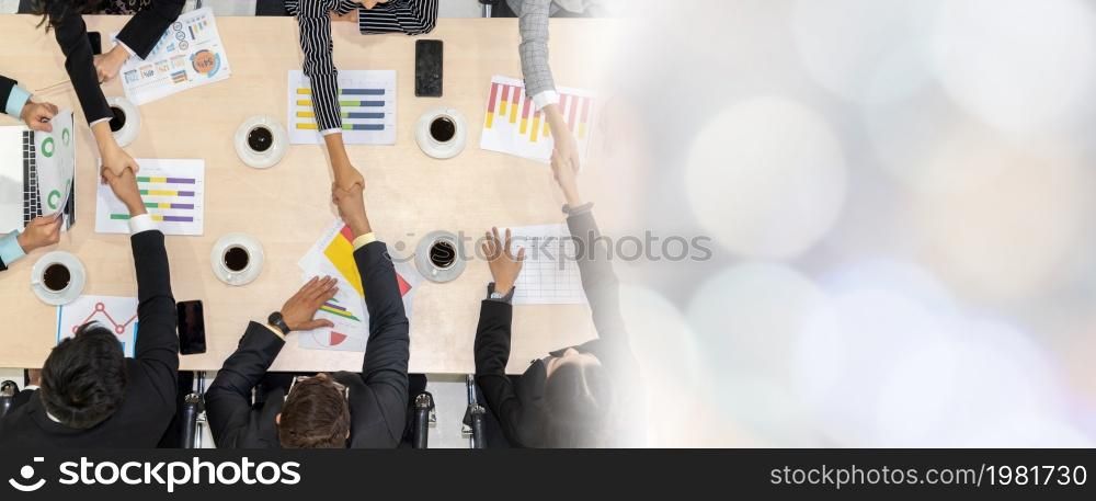 Group business people handshake at meeting table in office together with confident shot from top view . Young businessman and businesswoman workers express agreement of investment deal. broaden view. Group business people handshake at meeting table broaden view