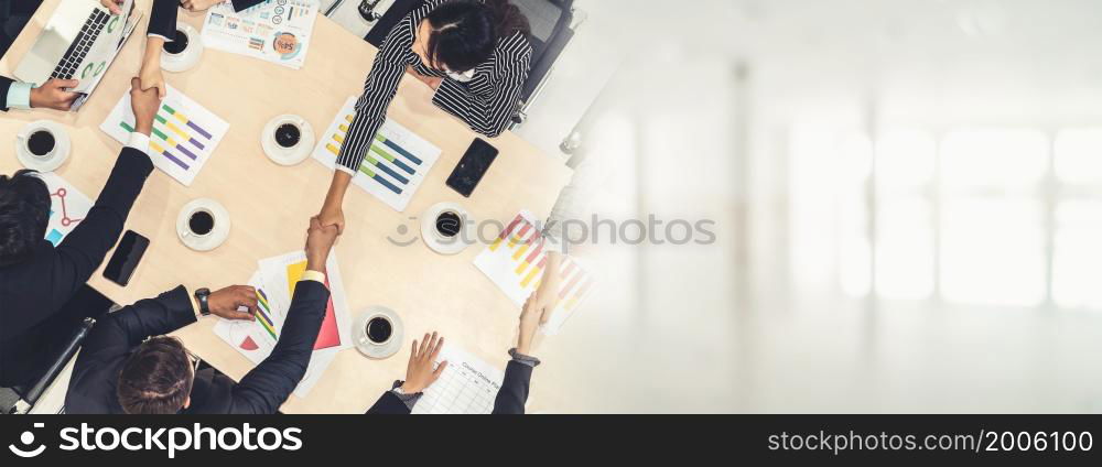 Group business people handshake at meeting table in office together with confident shot from top view . Young businessman and businesswoman workers express agreement of investment deal. broaden view. Group business people handshake at meeting table broaden view
