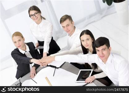 group business people stacking each other s hand desk