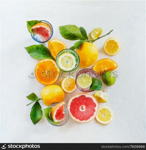 Group composition of various organic citrus fruits with green leaves on white background, top view. Healthy food. Ingredients. Vitamin. Halves and slices. Layout