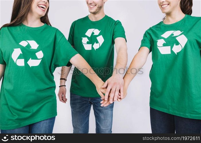 group friends green t shirt stacking their hands. High resolution photo. group friends green t shirt stacking their hands. High quality photo