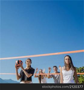 group friends playing beach volleyball