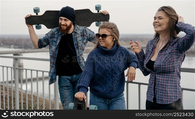 group friends posing together outdoors with skateboards