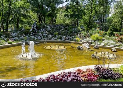 Group from small water fountains flowing in front beauty rockery, Sofia, Bulgaria