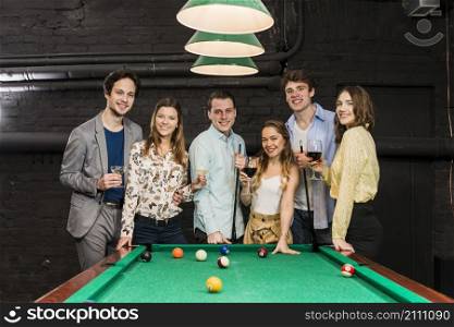 group happy smiling friends with drinks standing snooker table