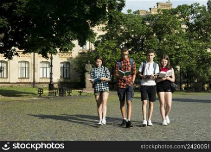 group highschool students reading while walking