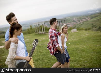 Group od young people having fun on a field trip in nature on mountain