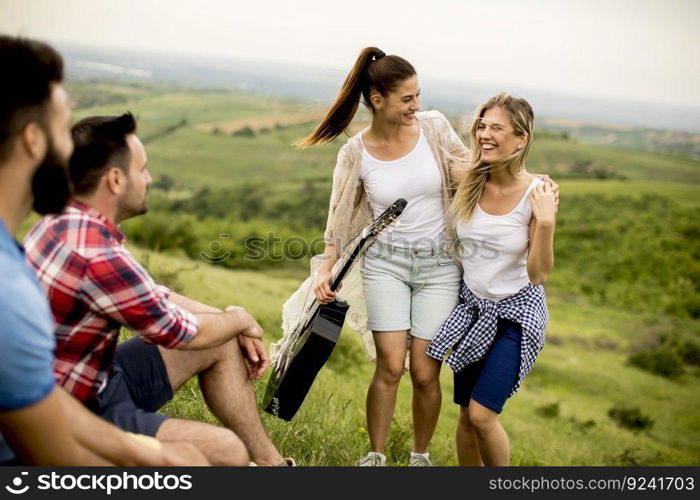 Group od young people having fun on a trip in nature on mountain