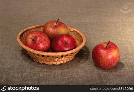 Group of a red apples in basket. Close-up. Still-life on linen textile backdrop.