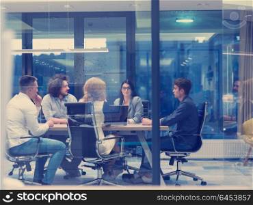 Group of a young business people discussing business plan at modern startup late night office building