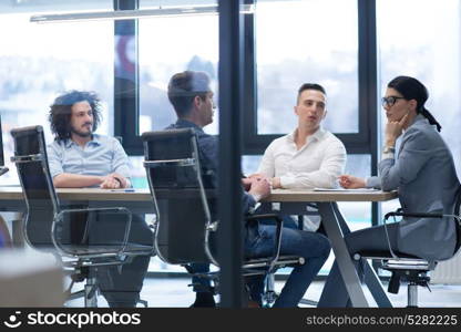 Group of a young business people discussing business plan at modern startup office building