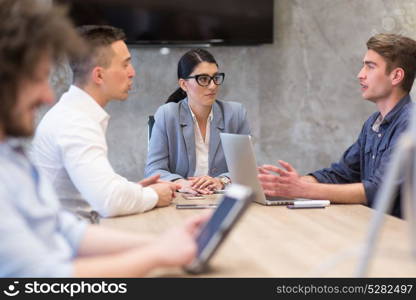 Group of a young business people discussing business plan at modern startup office building