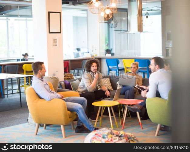 Group of a young business people discussing business plan at modern startup office building