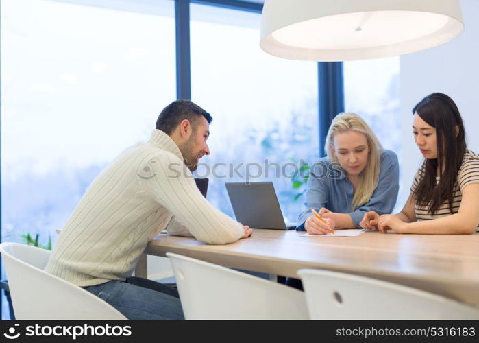 Group of a young business people discussing business plan at modern startup office building