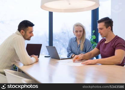 Group of a young business people discussing business plan at modern startup office building