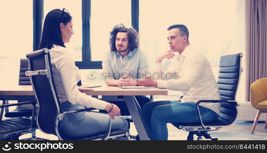 Group of a young business people discussing business plan at modern startup office building