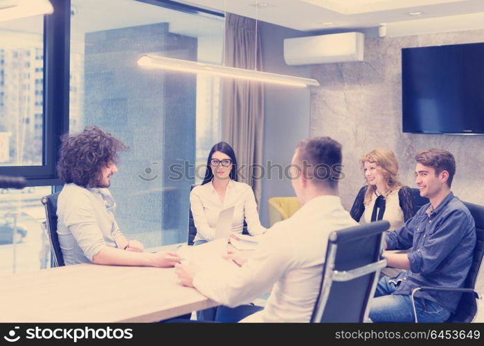 Group of a young business people discussing business plan at modern startup office building