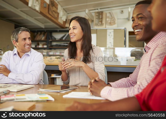 Group Of Architects Sitting Around Table Having Meeting