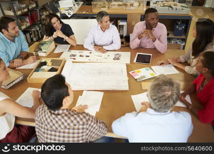 Group Of Architects Sitting Around Table Having Meeting