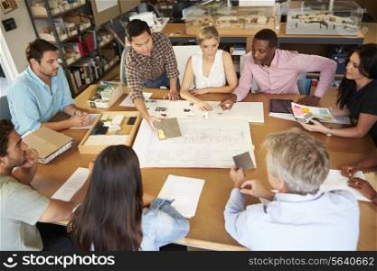 Group Of Architects Sitting Around Table Having Meeting