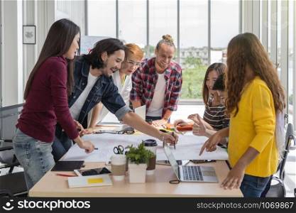 Group Of Asian and Multiethnic Business people with casual suit brainstorming and working with the project chart on the table together in happy action in the modern workplace, people business group concept