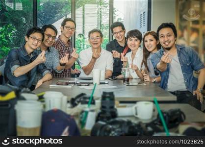 Group Of Asian Business people with casual suit doing small heart with happy action and celebrate in the Office or coffee shop, people business group concept