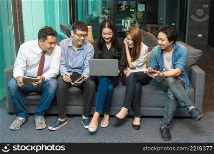Group Of Asian Business people with casual suit using the technology mobile, tablet, laptop and computer for working or social network in modern Office,people business group concept