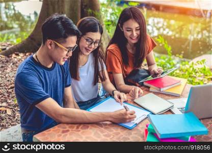 Group of Asian college student reading books and tutoring special class for exam on table at outdoors. Happiness and Education learning concept. Back to school concept. Teen and people theme.