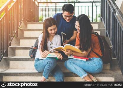 Group of Asian college student using tablet and mobile phone outside classroom. Happiness and Education learning concept. Back to school concept. Teen and people theme. Outdoors and Technology theme.