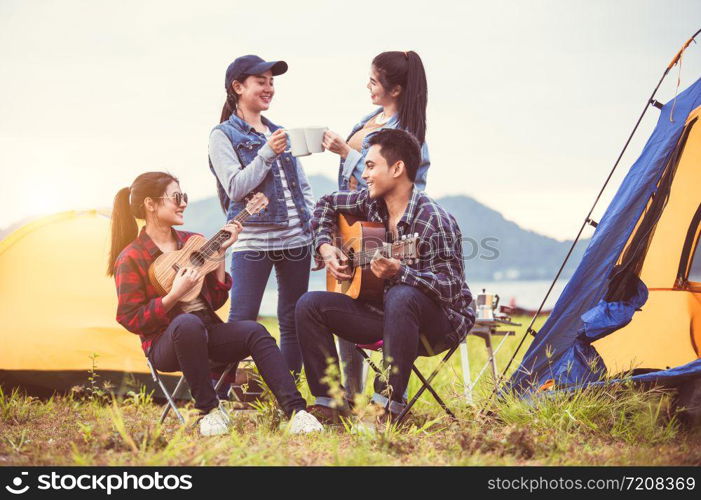 Group of Asian friendship clinking drinking bottle glass for celebrating in private party with mountain and lake view background. People lifestyle travel on vacation concept. Picnic and camping tent